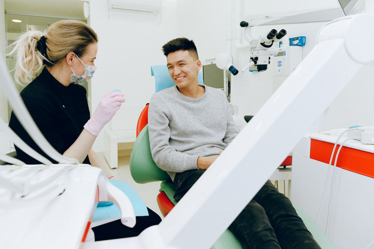 Dentist profesional melayani pasien di klinik gigi modern